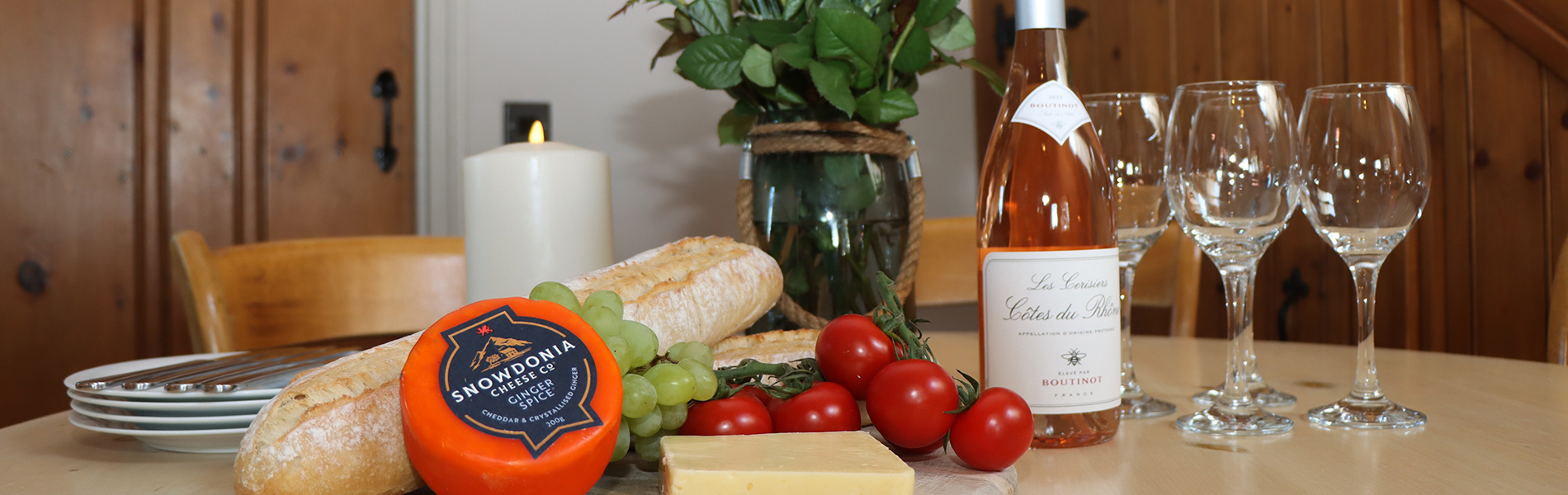 a display on the dining table of wine and foods like cheese and bread