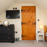 wooden door, single bed and chest of drawers
