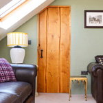wooden door with two dark leather sofas