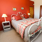 double bed with red wall behind