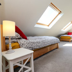 three single beds with door to bathroom in the back