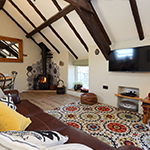 ystafell fyw gyda soffa a llosgwr coed