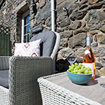 ardal eistedd awyr agored gyda grawnwin a gwin ar y bwrdd