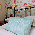 ffrâm gwely metel du wedi'i haddurno â gobenyddion glas