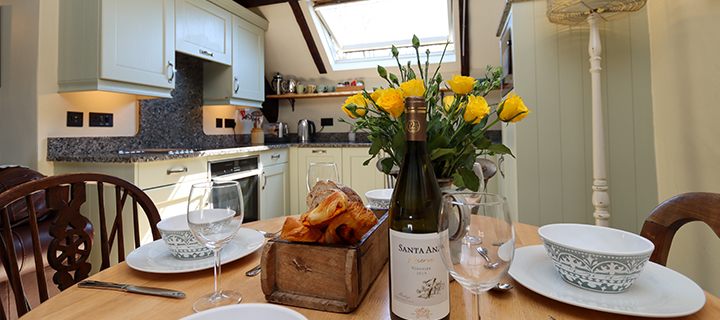 bwrdd bwyd gyda llestri, blodau a gwin