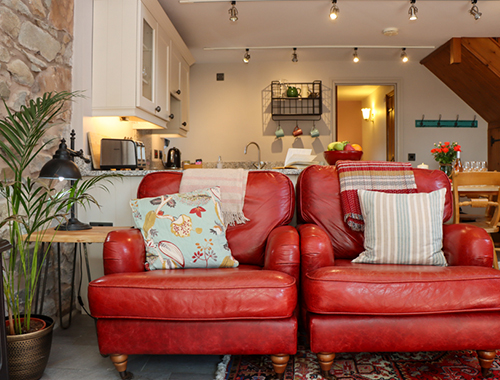 dwy gadair ledr goch yn stabal