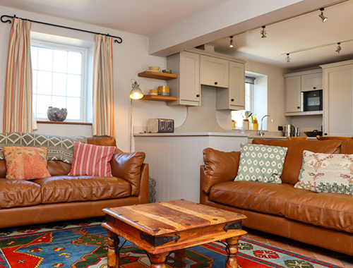 ystafell fyw efo dwy soffa ledr yn ysgubor